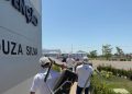 Profissionais de saúde transportando equipamentos em área externa de uma unidade médica.